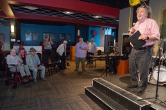 Philip Morris, CEO of Proctors Collaborative, speaks before presenting a plaque recognizing longtime Capital Region jazz historian Tim Coakley (far left) during Jazz on Jay in Robb Alley at Proctors in Schenectady on June 26, 2025. Photo by Kevin Montano for Proctors Collaborative.